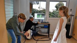 <p>Handstaubsaugergroß, aber so teuer wie ein Kleinwagen: Mit einemhochmodernen mobilen 3D-Scanner wird hier das Kommunionkind Mariella Ehrmann von Ivonne Leuchs abgescannt, um später anhand der Daten mit Hilfe eine 3D-Druckers eine Miniaturskulptur von ihr entstehen zu lassen.</p>
