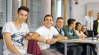 <p>Gastlehrer "Fran" aus Teneriffa diskutiert die wirtschaftliche Lage der Insel in der Fachklasse für Groß- und Außenhandel. Interessiert begleiten ihn der Schulleiter Wilhelm Ehrenfried (hinten links) sowie sein Betreuer Studiendirektor Rüdiger Keimel (Zweiter von rechts) und der Kooperationsbeauftragte der Kaufmännischen Schule Bad Mergentheim Eberhard Vollmer (rechts)".</p>