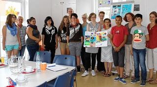 <p>Vier Kinder, die im Wespinstift leben (Jasmine und Elma halten das Mitmach-Buch, rechts daneben Manuel und René), brachten das Buch gemeinsam mit Kunsttherapeutin Kerstin Schoch (dahinter) und Sozialpädagogen Stephanie Bauer (rechts) von Mannheim nach Creglingen. Das Bild zeigt sie mit Jugendlichen und Pädagogen der Jugendhilfe Creglingen.</p>