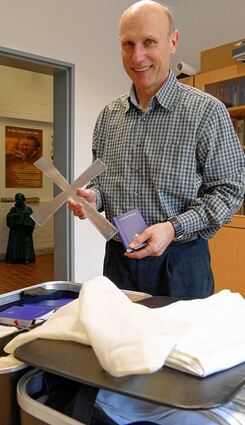 <p>Ein "Feldkreuz" aus dem Hartschalenkoffer: Pfarrer Stephan Aupperle mit seinem geistlichen Reisegepäck.</p>