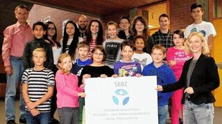 <p>Erfreut präsentieren Schüler und Lehrer der ehemaligen Florian-Geyer-Förderschule in Lauda gemeinsam mit Rektorin Tanja Rygiel (vorne rechts) das neue Logo des jetzigen "Sonderpädagogischen Bildungs- und Beratungszentrums (SBBZ) Lauda-Königshofen" mit dem Förderschwerpunkt Lernen.</p>