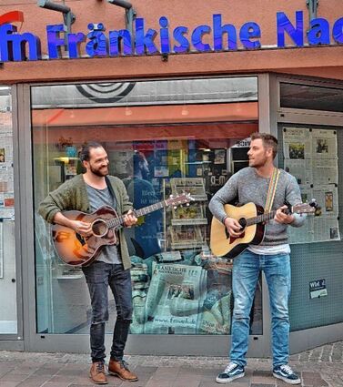 <p>"Jetzt und Hier" bei den Fränkischen Nachrichten: René Gold (links) aus Osterburken und Sebi Deuchert aus Weilbach gaben nach dem Besuch in unserer Lokalredaktion in der Buchener Fußgängerzone einige Lieder von ihrem ersten eigenen Studio-Album mit dem Titel "Spitzenteam" zum Besten.</p>