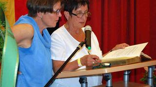 Christa Lutz (rechts) trägt sich ins goldene Partnerschaftsbuch ein.