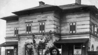Rita Schreck 1950 vor dem Haltepunkt Unterbalbach. Das Gebäude war bis 1. Oktober 1961 in Betrieb.