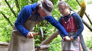 Farmleiter Axel Demmel hilft Robin beim Schmieden.