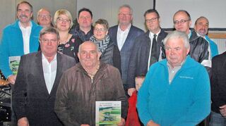 Im „Fuchsenloch“: Die Grußwortredner und Aktiven mit Höpfingens Bürgermeister Adalbert Hauck. Das Buch halten Manfred Baumann und Lothar Klotzbücher als letzte lebende Erstbezieher der Siedlung im Sommer 1969.