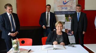 Bei ihrem Besuch am GTO in Osterburken trug sich Kultusministerin Dr. Susanne Eisenmann (vorne) im Beisein von Bürgermeister Jürgen Galm, MdL Peter Hauk, Landrat Dr. Achim Brötel und Schulleiterin Regina Krudewig-Bartel (von links) ins Goldene Buch der Stadt ein.