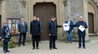 Zur Übergabe der Förderplakette versammelten sich neben Alfred Beetz ( Zweiter von rechts) und Pfarrer Dietmar Reizel (mit Barett) auch Ortsvorsteherin Anne-Katrin Kämmer (rechts), Bürgermeister Ralf Killian und einige Kirchengemeinderatsmitglieder.