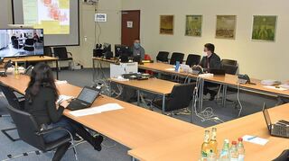 Der Arbeitsstab Corona mit (um den Tisch herum, von links) Pressesprecher Markus Moll, Justiziarin Jasmin Kaibel, Kreisbrandmeister Andreas Geyer, Gesundheits- und Sozialdezernentin Elisabeth Krug, Erstem Landesbeamten Christoph Schauder und Lagekartenführer Gerald Hauck spricht per Videokonferenz mit den Ärzten im Gesundheitsamt.