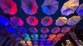 Zum Abschluss der „Umbrella Street“-Aktion leuchten morgens und abends bunte Strahler auf die weißen Schirme.