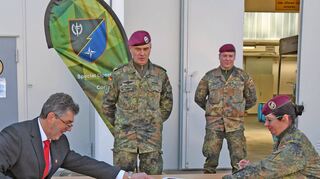 Bürgermeister Volker Rohm (links) und Oberstleutnant Carolin Bongartz unterzeichnen die Patenschaftsurkunde zwischen der Gemeinde Hardheim und der Stabs- und Führungsunterstützungskompanie SOCC im Beisein von Brigadegeneral Pfeifer (Zweiter von links) und Bongartz’ Nachfolger, Hauptmann Steffen Knehr.