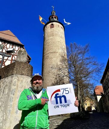 Für das Motiv mit dem Jubiläumsplakat, das von nun an auf Wanderschaft durchs FN-Verbreitungsgebiet geht, hat sich Volker Baumann seinen geliebten Schlossplatz mit dem Türmersturm ausgesucht.