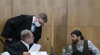 Der Angeklagte Franco A. (r.) spricht zum Prozessauftakt mit seinem Verteidiger Johannes Hock (sitzend) und Moritz Schmitt-Fricke.