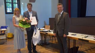 Bürgermeister Volker Rohm wurde für 40 Jahre im öffentlichen Dienst im Rahmen der Gemeinderatssitzung von Landrat Dr. Achim Brötel (rechts) gewürdigt. Für Rohms Frau Andrea gab es einen Blumengruß.