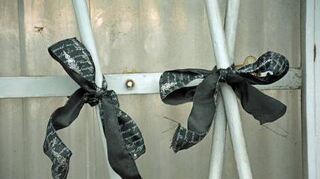 Schwarze Trauerschleifen am Werkstor an der Laukhuff-Straße