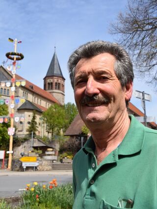 Walter Frank mit dem Turm des Gemeindezentrums im Hintergrund – ein Wahrzeichen des Ortes.