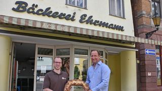 Bäckermeister Marcus Ehrmann übergibt sein Geschäft am Gänsmarkt symbolisch an Bäckermeister Christian Bamberger aus Igersheim.