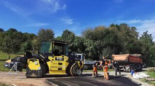 Nur noch letzte Handgriffe an der Einmündung zur Straße zum Sportplatz in Kembach, dann ist der Asphalt auf dem neuen Radweg bis zur Landesgrenze komplett aufgebracht. Es folgen die Arbeiten am Bankett, und der Abschnitt kann freigegeben werden. Der Radweg ist dann bis Neubrunn durchgängig.