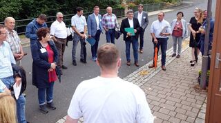 Nahversorgung: Mitglieder der Bewertungskommission des Wettbewerbs „Unser Dorf hat Zukunft“ und die Verantwortlichen von Laudenbach vor der Genusshütte von Thomas und Manuela Deißler im Gespräch.