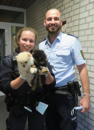 Die Streifenwagenbesatzung mit den beiden Welpen.