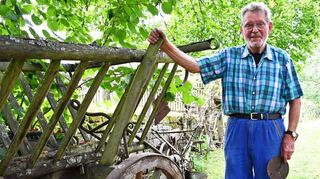 Franz Schell vor einem Wagen, wie er früher in den Ortschaften oft zu sehen war. Im Gespräch berichtet er von der Arbeit, wenn die Räder der Karren beschlagen wurden.