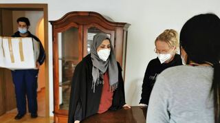 Shaimaa Hussein, Nadine Veit und Nada beim Einräumen des Wohnzimmers. Mohamad bringt schon mal Geschirr.