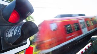 Ein S-Bahn-Zug passiert einen geschlossenen Bahnübergang. Nachdem nun auch in Mainfranken ein Regional-S-Bahn-Konzept umgesetzt wird, ist es der Wunsch von „Pro Bahn“ und VCD, dass auch die Region Neckar-Odenwald an das Netz angeschlossen wird.