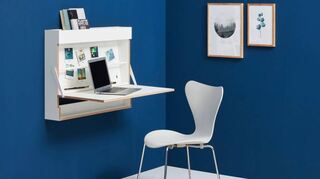 Der minimalistische Arbeitsplatz mit klappbarem Schreibtisch von Müller Möbelfabrikation. Der Stuhl ist ein Klassiker von Arne Jacobsen.