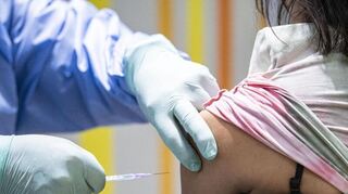 Eine Person wird im Impfzentrum Berlin-Tegel von einem Impfarzt gegen das Coronavirus geimpft. Foto: Fabian Sommer/dpa