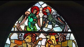 Evangelistensymbole finden sich m Osten und Westen der Weikersheimer Stadtkirche. Das Portalfenster hat Walter Kohler (1903 – 1945) geschaffen.