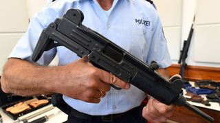 Ein Polizeibeamter hält eine Maschinenpistole vom Typ Uzi in den Händen. Immer wieder gelangen solche Schnellfeuerwaffen bei illegalen Geschäften in den Besitz von Privatpersonen – jetzt stand ein Mann aus dem südlichen Main-Tauber-Kreis wegen eines gefährlichen Waffendeals vor Gericht.