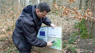 Alexander Arnold von der Projektgruppe mit einer Infotafel zum Flowtrail.