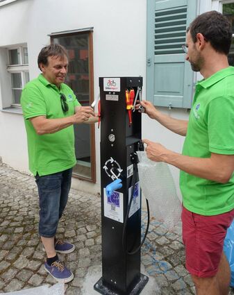 Eberhard Belz, Koordinator des Stadtradelns in Adelsheim, und Bürgermeister Wolfram Bernhardt enthüllen eine Reparatursäule für Fahrräder, die im Rathausinnenhof steht. Dort gibt es „Erste Hilfe“ für Radfahrer.