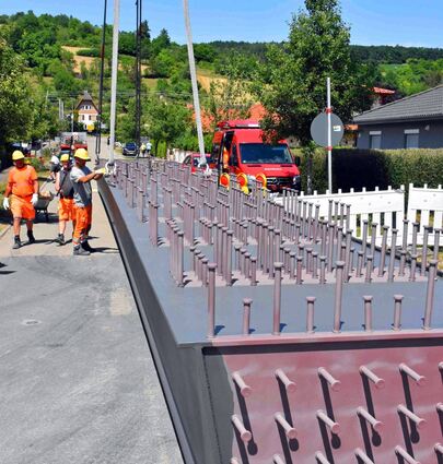 Die per Schwertransport angelieferten Stahlhohlkästen wurden zunächst von den Arbeitern des Bauunternehmens Leonhard Weiss mit Ketten am Kran befestigt.
