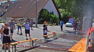 Einen „Mitmachtanz“ zeigten die 38 Kinder vom TSV Vorbachzimmern und dem Kindergarten Wolkenschloss, die seit Jahren eine Kooperation haben, vor dem Dorfgemeinschaftshaus des Ortes (Bild oben). Eine willkommende Abkühlung bot der Stand der Jugendfeuerwehr (unten links). Eine Fotoausstellung zeigte, wie sich Vorbachzimmern im Laufe der letzten 50 Jahre verändert hat (unten rechts).