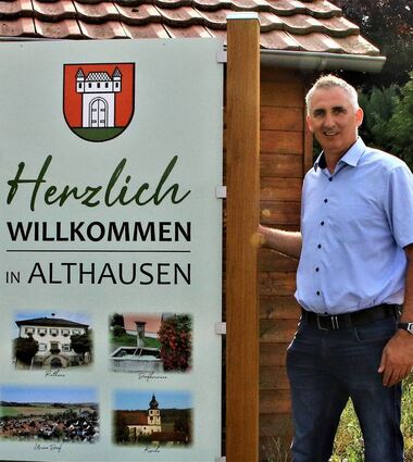 Ortsvorsteher Oliver Adelmann vor dem neuen Willkommensschild am Ortseingang. Althausen war die erste Gemeinde, die den Eingemeindungs-Vertragsabschluss mit der Kurstadt perfekt gemacht hat. Der Anschluss erfolgte am 1. Januar 1972.