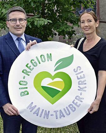 Christoph Schauder und Michaela von Koschitzky mit dem Logo der Bio-Region Main-Tauber-Kreis.