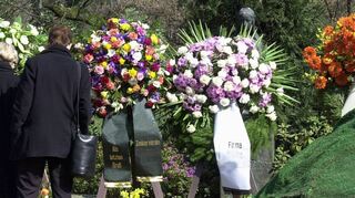 Trauernde stehen an einem neuen Grab. Die Friedhofsgebühren in Boxberg steigen teilweise deutlich.