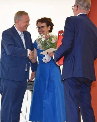 Landrat Dr. Matthias Neth (links) gratulierte Ruth Henn und überreichte ihr als Dank einen Blumenstrauß. Rechts ihr Mann.