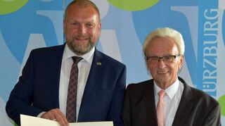 Erich Beck (rechts) sammelte in 50 Jahren unglaubliche zwölf Millionen Euro für soziale Projekte. Landrat Thomas Eberth verlieh ihm für sein Engagement den Kristallzinnbecher des Landkreises Würzburg.