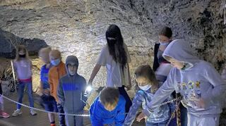 Mit T’aschenlampen gehen die jungen Höhlenforscher auf Entdeckungsreise.