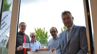 Landrat Dr. Achim Brötel (rechts) eröffnete die Secondhand-Boutique durch das Durchschneiden des Bandes.