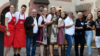 „Wein am Schloss“ eröffnet: Auf ein erfolgreiches Weinfest stießen die Organisatoren um Claudia Wölpper-Murphy (Vierte von rechts) und Jutta Schneider von der TaubertalVinothek (Fünfte von rechts) mit den Weinhoheiten aus Külsheim und Dertingen sowie Bürgermeisterstellvertreter Gerhard Baumann (Dritter von links) an.