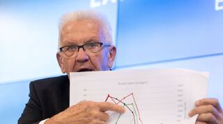 Winfried Kretschmann zeigt ein Schaubild zum Ausbau der Windkraft in Baden-Württemberg und Bayern.