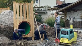 Daniel Müller (Mitte) und Sebastian Ehrenfried (rechts) auf der Baustelle des Römerspielplatzes Neptun in Osterburken.