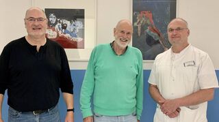 Der Facharzt für Urologie, Dr. David Brix, freut sich über die Bilder von H. Bernd Schepermann und Stephan Funk (links) in seinen Praxisräumen.