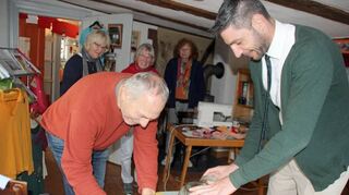 Bürgermeister Schuppert (rechts) betätigte sich im Weltladen bei der Auslosung als Glücksfee, Osmund Schneider (links) protokollierte die Reihenfolge der Gewinnerinnen.