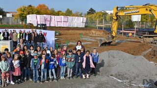 Schülerinnen und Schüler der Klassen 3b und 4d der Grundschule Bad Mergentheim freuen sich mit vielen Ehrengästen über die Grundsteinlegung für die zusätzliche Schule im Auenland.
