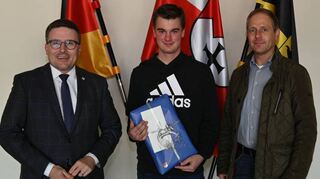 Landrat Christoph Schauder (links) gratuliert Alexander Kuhn zu seinem herausragenden Ergebnis. Auch Thomas Knörzer vom Straßenbauamt (rechts) freute sich über den Erfolg.
