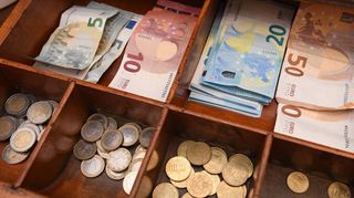 Geld liegt in einer Ladenkasse: Wer mit dem Fremdenverkehr in der Kurstadt Geld verdient, muss – sofern er Gewinn macht – eine Abgabe an die Stadt entrichten.